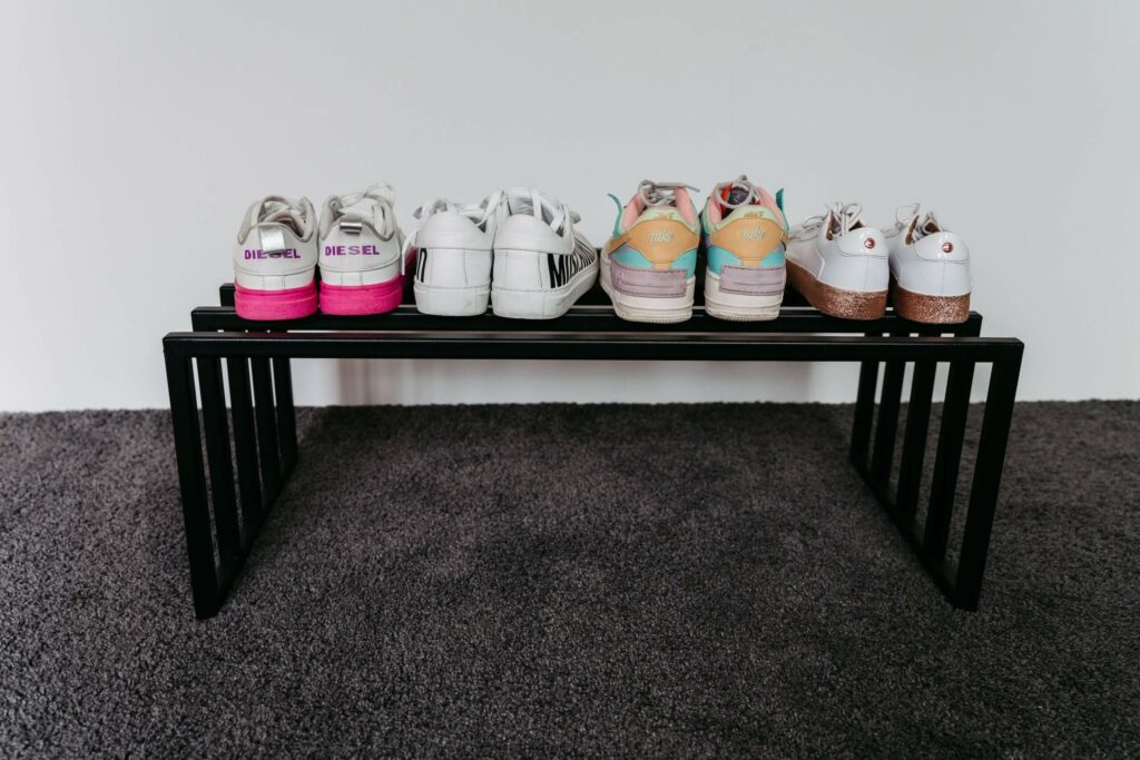 Schwarzes Schuhregal mit weißen Turnschuhen