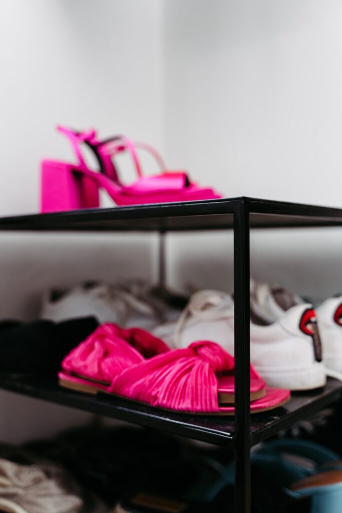 Pinke Schuhe auf schwarzem Stahlregal